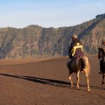 People on horseback traversing the Sea of Sand