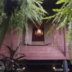 Chandelier viewed through a window of a wooden house