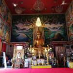 Golden Buddha in seated position in altar