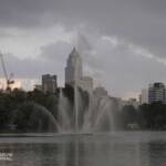 Fountain in artificial lake, high-rise buildings at the back